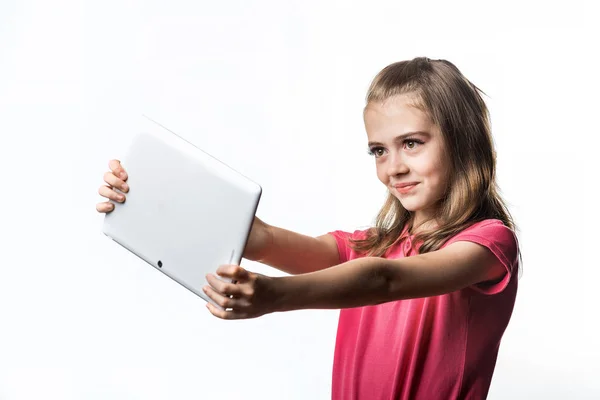 Little girl with a tablet computer on a white background. Emotio — Stock Photo, Image