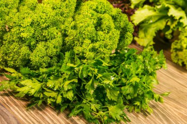 Taze yeşil dereotu ve maydanoz otlar rustik ahşap masa üzerinde. Baharat mutfak için. Salata.