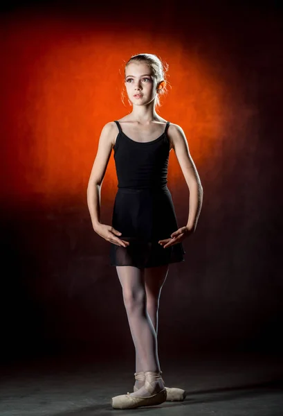 Bailarina. Linda niña posando y bailando en el estudio. La chica está estudiando ballet. Fondo oscuro . —  Fotos de Stock