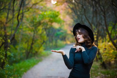 Çekici bir genç bayan siyah şapkalı bir portresi. Sonbahar Park. Kadın duygular.