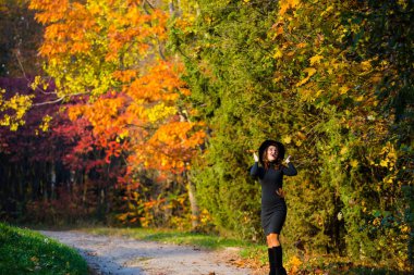 Genç güzel Moda Bayan siyah şapka geniş ekledi. Sonbahar manzara.