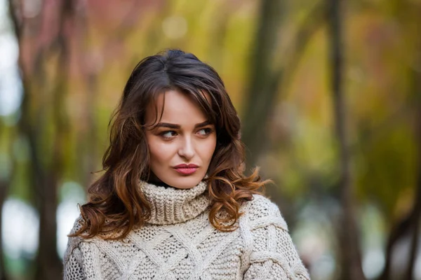 Hermosa mujer emocional en un parque de otoño, mirando hacia otro lado . — Foto de Stock