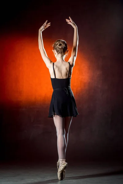 Joven e increíblemente hermosa bailarina posando y bailando en el estudio. Bailarina de ballet. Pequeño vestido negro . — Foto de Stock