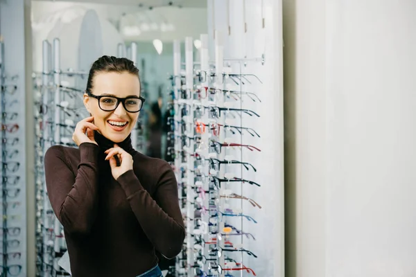 Young girl buys glasses. Optics. Emotions. ?ptical store