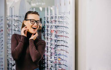 Güzel kız gözlükçü mağazasında gözlüklü. Görme düzeltme. Optik. Duygular. Göz hastalıkları.