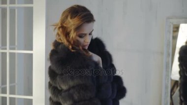 Genç seksi bir kadın paltosunu alır ve onun iç çamaşırında kalır.