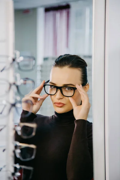 Hermosa chica con gafas en la tienda de óptica. Corrección de la vista. Óptica. Emociones. Oftalmología . — Foto de Stock