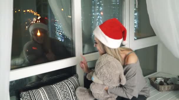 Vacker Kvinna Med Nallebjörn Sitter Vid Fönstret Väntar Ett Jullov — Stockvideo