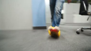 Adam komik sarı terlik içinde ofis etrafında yürür. Ofisine erkek ayak yakın çekim.