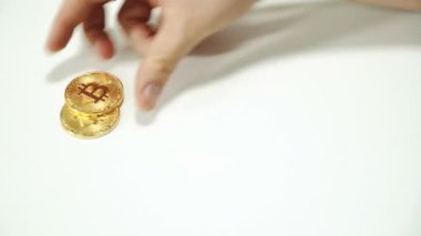Erkekler ellerini masanın üzerine altın bitcoin yayıldı. Cryptocurrency altın şeklinde.