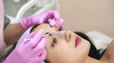 Doktor güzellik uzmanı Botulinum toksin enjeksiyon yapar. Sıkma ve kırışıklıkları yumuşatma yordamı. Gençleştirici yüz enjeksiyonları.