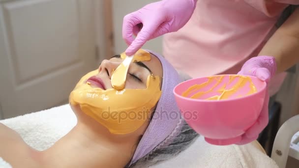 Gesichtspeeling Maske. Frau bekommt Gesichtsbehandlung durch Kosmetikerin im Wellness-Salon. Kosmetikerin. Nahaufnahme