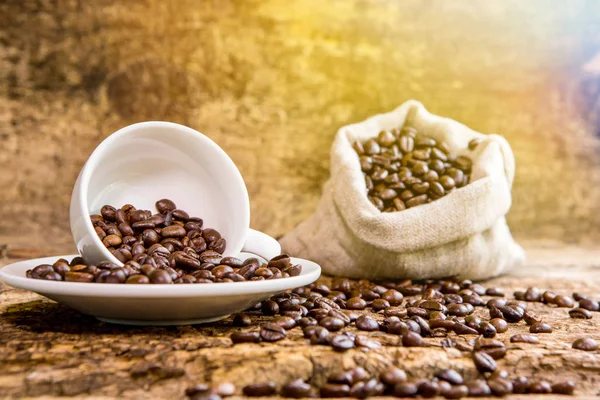 Coffee cup with coffee bag on wooden table. Coffee cup and coffee beans on a wooden table and sack background