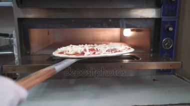 Şef ham pizza fırın içine koyar. Pizza yapma. Yemek yemek.