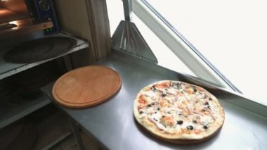 Profesyonel şef şimdi pişmiş pizza koyar. İtalyan Pizza fırından koyarak. Hazır'dır