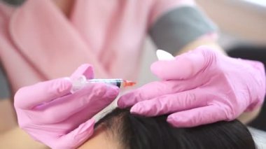 Yakışıklı kadın iğne başından alır. Mezoterapi kavramı. Saç ve diğerlerinin gelişimi güçlendirmek için itme