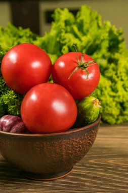 Rustik ahşap bir masa üzerinde bir seramik kase taze sebze. Sağlıklı bir diyet kavramı