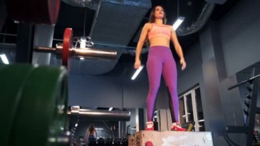 Spor salonunda spor salonundaki spor salonuna atlayan jimnastik hocası. Spor konsepti yağ yakma ve sağlıklı bir yaşam tarzı.
