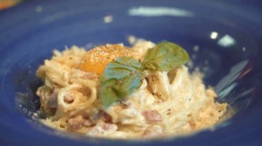 Makarna Carbonara. Pastırma, fesleğen, parmesan peyniri ve sarısı spagetti. İtalyan mutfağı.