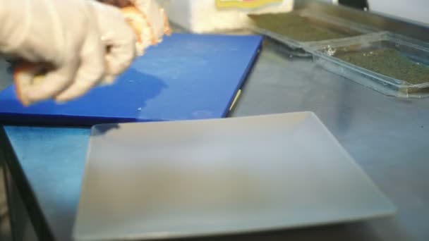 戴手套的厨师把寿司放在盘子里 新鲜可口的寿司卷 — 图库视频影像