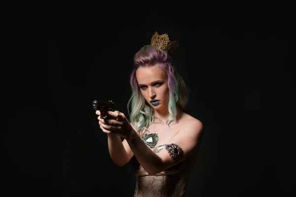 Joven mujer rubia hermosa con un arma en la mano. Chica con el pelo largo y colorido —  Fotos de Stock