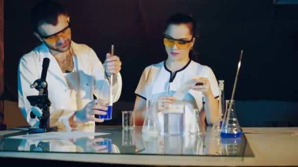 Два Хіміки Досліджують Різні Рідини Трубках Експерименти Лабораторії — стокове відео