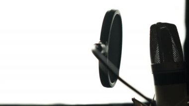 Güzellik kadını mikrofon ile. Profesyonel kayıt stüdyosu. Yakın çekim yüz. Siyah ve beyaz