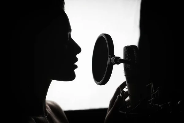 Mujer cantando en el estudio de grabación. Perfil de una mujer con un —  Fotos de Stock