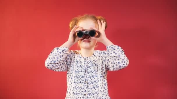 Μικρό Κορίτσι Ψάχνει Μέσα Από Κιάλια Απομονωμένα Κόκκινο Φόντο — Αρχείο Βίντεο