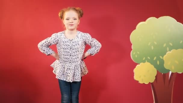 Uma Menina Gira Estúdio Criança Ruiva Bonito Fundo Vermelho — Vídeo de Stock