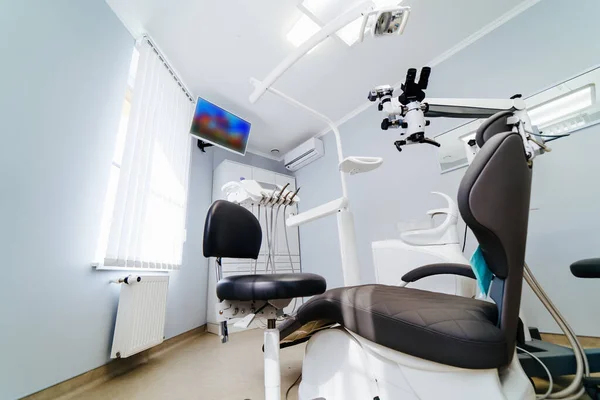 Nowoczesne wnętrze gabinetu dentystycznego z krzesłem i narzędziami. Mikroskop w stomatologii. — Zdjęcie stockowe