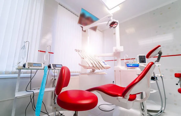 Interior de um armário estomatológico. Cadeira vermelha e paredes brancas . — Fotografia de Stock