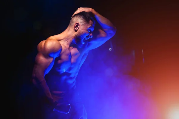 Homens atléticos fortes brutais bombeando músculos. Conceito de treino e musculação. Filtro de luz azul. Homem bonito com tronco nu. Modelo de fitness está posando. — Fotografia de Stock