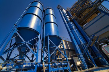 Asfalt, çimento ve beton üretimi için ekipman. Beton fabrikası. Asfalt bitkisinin yüksek kulesi. Zararlı üretim. Bitumen ve çakıl karışımı, bir karışım makinesi..