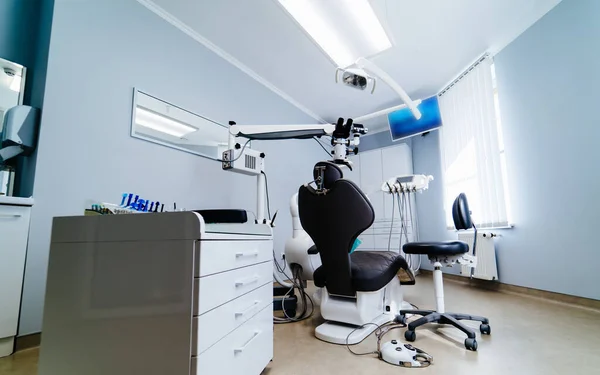 Moderna oficina de odontología interior con silla y herramientas. Microscopio en estomatología . — Foto de Stock