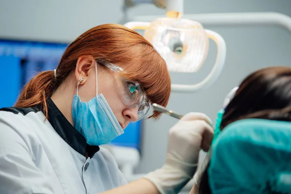 Estomatologista jovem do sexo feminino tratar os dentes do paciente. Conceito de dentes saudáveis. Foco seletivo. — Fotografia de Stock