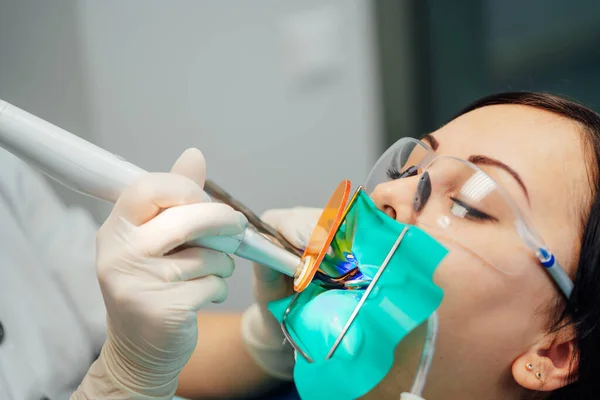 Schöne Patientin mit Zahnbehandlung in der Zahnarztpraxis. Frauen besuchen die Stomatologie. Mundpflege. — Stockfoto