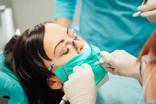 Schöne Patientin mit Zahnbehandlung in der Zahnarztpraxis. Frauen besuchen die Stomatologie. Mundpflege. — Stockfoto