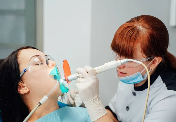 Dentystka pracuje w nowoczesnej klinice stomatologicznej. Instrument stomatologiczny w klinice dentystycznej. Medycyna, zdrowie, koncepcja stomatologii. — Zdjęcie stockowe