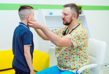 Doktor çocuk lenf bezlerini kontrol ediyor. Seçici odak.