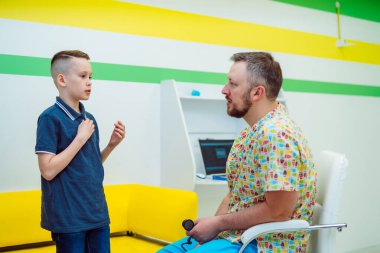 Çocuk hastanedeki doktorun muayenesinde belirtileri anlatıyor. Çocuk doktoru tarafından klinikte tıbbi muayene. Pediyatrik, sağlık ve insan konsepti.