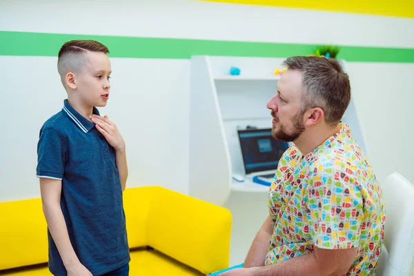 Bambino che dice sintomi alla consultazione del medico in ospedale. Esame medico in clinica da pediatra. Concetto pediatrico, sanitario e di persone. — Foto Stock