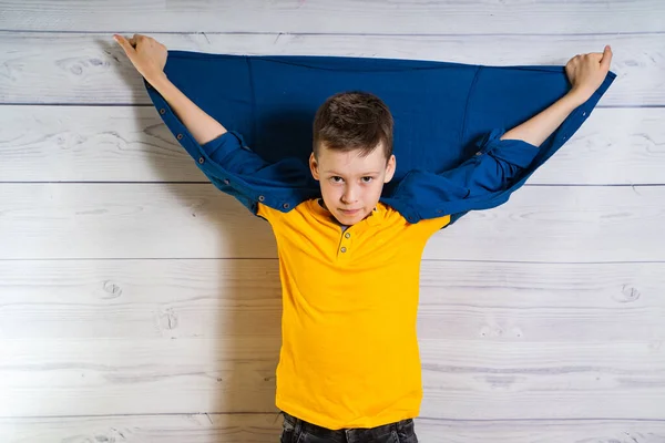 Beau petit garçon posant devant la caméra avec les mains et la veste vers le haut dans le dos. Brunette adolescente en studio. Bonne conception de l'enfance — Photo