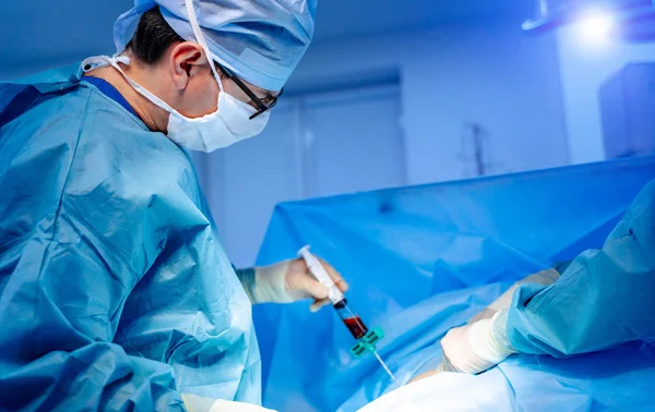 Transplantation de moelle osseuse. Chirurgiens en uniforme médical et masques travaillant en salle d'opération. — Photo