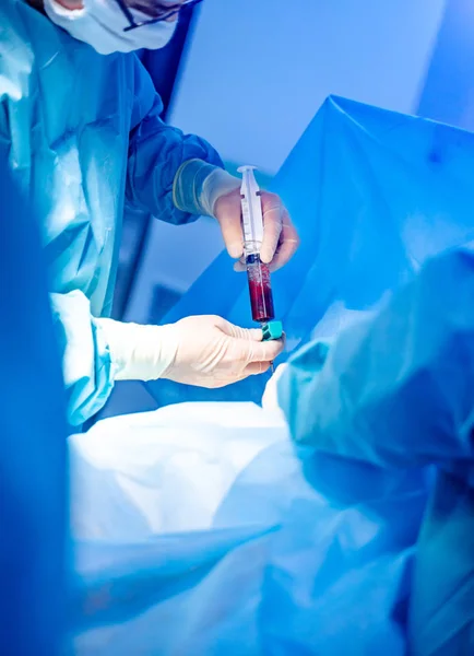 Platelet-Rich plasma preparation. Plasma in syringe. Modern equipment in operating room. — Stock Photo, Image