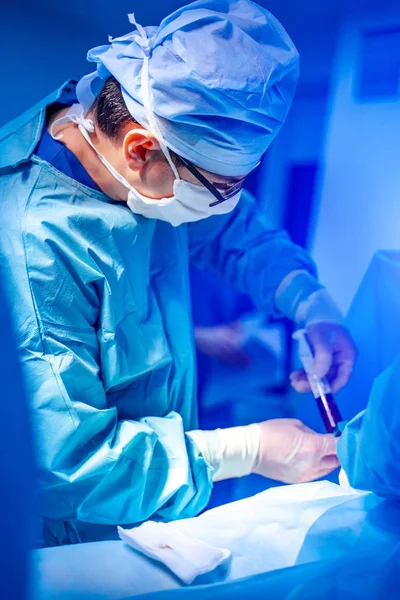 Stem cells operation. Surgeons team working. Bone marrow transplant operation. Plasma in syringe. — Stock Photo, Image