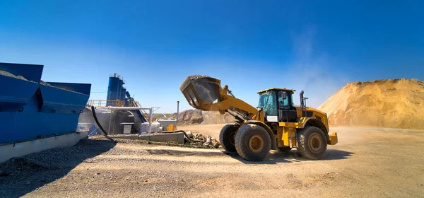 Gelber Bagger bei der Reinigung von Hinterhöfen im Industriegebiet. Selektiver Fokus. Industriegebiet. blauer Himmel Hintergrund. — Stockfoto