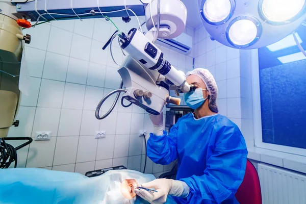 Cirurgia ocular. Um paciente e cirurgião na sala de cirurgia durante a cirurgia oftálmica. Paciente sob microscópio cirúrgico. Correção de visão — Fotografia de Stock