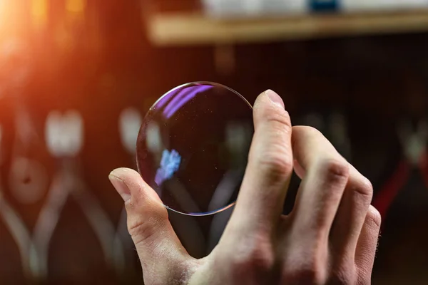 ophthalmologist hands close up, showing a glass lens for spectac