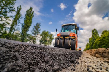 Yol silindiri yeni asfaltı dümdüz ediyor. Wo 'da ağır titreşim silindiri